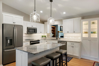 This is an example of a kitchen in Minneapolis with a submerged sink, shaker cabinets, turquoise cabinets, granite worktops, ceramic splashback, light hardwood flooring and an island.
