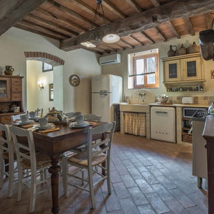 Esempio di una cucina country di medie dimensioni con lavello stile country, paraspruzzi con piastrelle in pietra e pavimento in terracotta