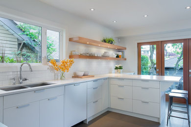 Mid-sized trendy u-shaped open concept kitchen photo in Vancouver with a double-bowl sink and flat-panel cabinets