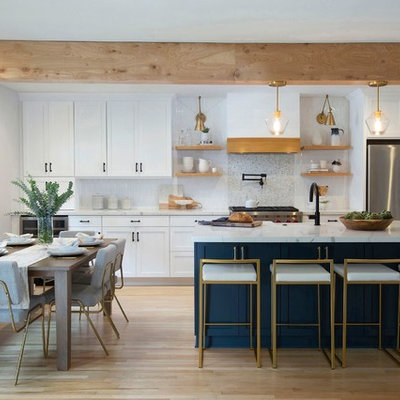 Inspiration for a mid-sized transitional galley light wood floor and beige floor open concept kitchen remodel in Denver with shaker cabinets, white cabinets, quartz countertops, an island, white countertops, a farmhouse sink, white backsplash, ceramic backsplash and stainless steel appliances