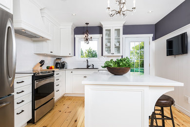 Enclosed kitchen - mid-sized transitional l-shaped light wood floor enclosed kitchen idea in Montreal with an island, shaker cabinets, gray cabinets, quartz countertops, white backsplash, subway tile backsplash, stainless steel appliances and a drop-in sink
