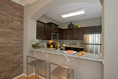 Transitional l-shaped enclosed kitchen photo in Other with an undermount sink