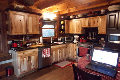 Inspiration for a small rustic l-shaped vinyl floor and brown floor open concept kitchen remodel in Indianapolis with an undermount sink, raised-panel cabinets, granite countertops, black backsplash, wood backsplash, stainless steel appliances and black countertops