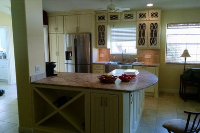Idéer för mellanstora amerikanska linjära kök med öppen planlösning, med en rustik diskho, luckor med infälld panel, beige skåp, granitbänkskiva, brunt stänkskydd, stänkskydd i stenkakel, rostfria vitvaror, klinkergolv i keramik, en köksö och beiget golv