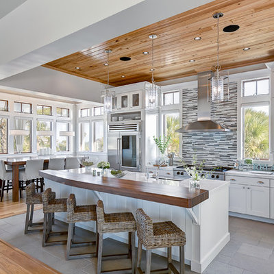 Example of a beach style l-shaped kitchen design in Jacksonville with matchstick tile backsplash, marble countertops, shaker cabinets, white cabinets, stainless steel appliances and multicolored backsplash