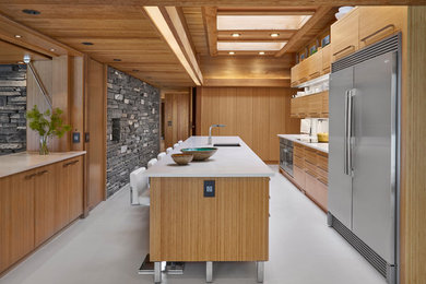 Example of a large minimalist galley concrete floor and gray floor enclosed kitchen design in Edmonton with an undermount sink, flat-panel cabinets, light wood cabinets, stainless steel appliances, an island, quartz countertops, white backsplash and glass sheet backsplash
