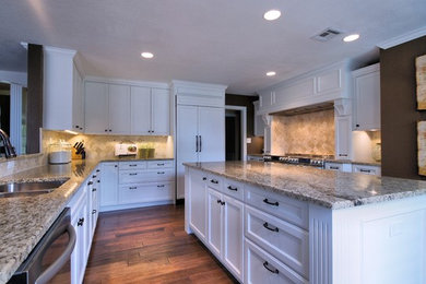 U-shaped kitchen photo in Austin with shaker cabinets, white cabinets, granite countertops, beige backsplash, stainless steel appliances and an island