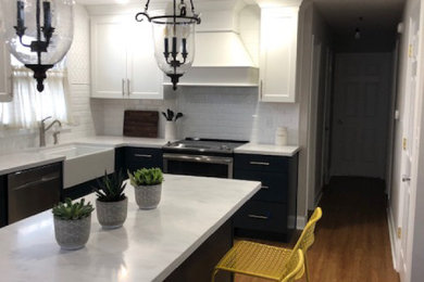 Inspiration for a mid-sized french country l-shaped vinyl floor and brown floor enclosed kitchen remodel in Indianapolis with a farmhouse sink, shaker cabinets, white cabinets, solid surface countertops, white backsplash, ceramic backsplash, stainless steel appliances, an island and white countertops
