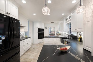 Transitional kitchen photo in Tampa with a single-bowl sink, raised-panel cabinets, white cabinets, soapstone countertops, white backsplash, glass tile backsplash and black appliances