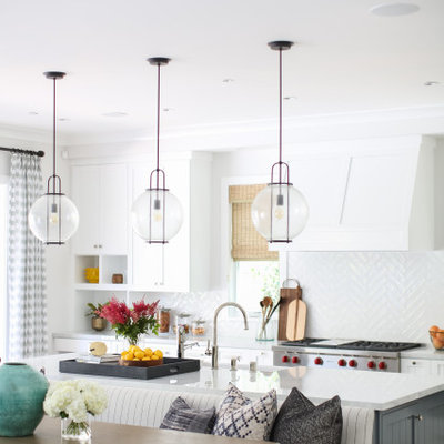 Eat-in kitchen - large transitional galley brown floor eat-in kitchen idea in Orange County with an undermount sink, shaker cabinets, white cabinets, white backsplash, stainless steel appliances, an island and white countertops