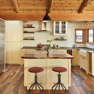 This is an example of a beach style kitchen in Seattle with an integrated sink, shaker cabinets, with island and grey benchtop.