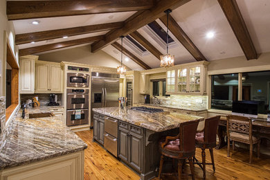 Inspiration for a mid-sized rustic u-shaped enclosed kitchen remodel in Jacksonville with beaded inset cabinets, beige cabinets, granite countertops, beige backsplash, stone tile backsplash, stainless steel appliances and an island