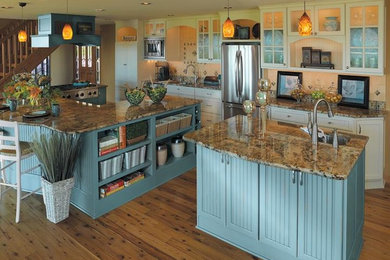Idéer för att renovera ett stort linjärt kök med öppen planlösning, med en nedsänkt diskho, luckor med infälld panel, blå skåp, granitbänkskiva, beige stänkskydd, stänkskydd i keramik, rostfria vitvaror, mellanmörkt trägolv och flera köksöar