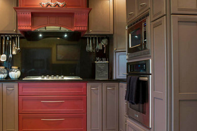 Esempio di una cucina minimal chiusa e di medie dimensioni con top in onice, elettrodomestici in acciaio inossidabile, ante con riquadro incassato, ante marroni, paraspruzzi nero e paraspruzzi con lastra di vetro
