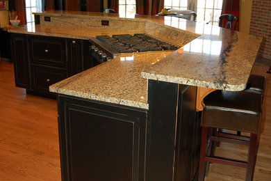 Classic kitchen in Chicago with flat-panel cabinets, dark wood cabinets and granite worktops.