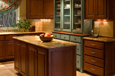 Eat-in kitchen - large traditional l-shaped travertine floor eat-in kitchen idea in Orange County with a double-bowl sink, raised-panel cabinets, medium tone wood cabinets, granite countertops, beige backsplash, stone tile backsplash, stainless steel appliances and an island