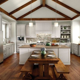 Ispirazione per una grande cucina chic con lavello sottopiano, ante a persiana, ante grigie, paraspruzzi grigio, paraspruzzi con piastrelle a listelli, elettrodomestici in acciaio inossidabile, pavimento in legno massello medio, top in quarzo composito e pavimento marrone