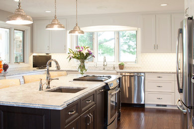 Example of a trendy u-shaped medium tone wood floor eat-in kitchen design in Chicago with a farmhouse sink, raised-panel cabinets, white cabinets, white backsplash and an island