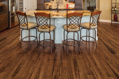 Eat-in kitchen - large traditional l-shaped medium tone wood floor eat-in kitchen idea in Seattle with louvered cabinets, dark wood cabinets, marble countertops, stainless steel appliances and an island