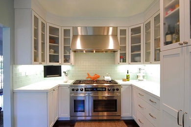 Elegant kitchen photo in Orange County with white cabinets, blue backsplash, stainless steel appliances and no island