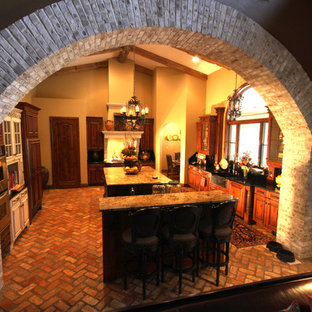 Mid-sized separate kitchen in Orlando with an undermount sink, beaded inset cabinets, beige cabinets, granite benchtops, black splashback, stone slab splashback, stainless steel appliances, brick floors and multiple islands.
