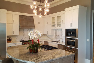 Mid-sized trendy l-shaped eat-in kitchen photo in Miami with a double-bowl sink, shaker cabinets, white cabinets, stainless steel appliances and an island