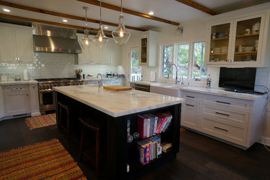 Open concept kitchen - large traditional l-shaped dark wood floor and brown floor open concept kitchen idea in San Diego with a farmhouse sink, shaker cabinets, white cabinets, marble countertops, white backsplash, subway tile backsplash, stainless steel appliances and an island