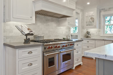 Example of a classic l-shaped open concept kitchen design in Portland with an undermount sink, white cabinets, quartzite countertops, subway tile backsplash and stainless steel appliances
