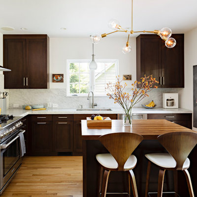 Kitchen - mid-sized contemporary l-shaped medium tone wood floor kitchen idea in Portland with wood countertops, stainless steel appliances, shaker cabinets, dark wood cabinets, white backsplash, stone slab backsplash and an undermount sink