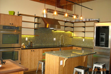 Inspiration for an industrial dark wood floor eat-in kitchen remodel in Portland with an undermount sink, flat-panel cabinets, light wood cabinets, recycled glass countertops, green backsplash, glass sheet backsplash, stainless steel appliances and an island