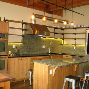 Photo of an industrial eat-in kitchen in Portland with an undermount sink, flat-panel cabinets, light wood cabinets, recycled glass benchtops, green splashback, glass sheet splashback, stainless steel appliances, dark hardwood floors and with island.