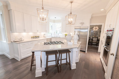 Inspiration for a large transitional l-shaped dark wood floor and brown floor eat-in kitchen remodel in Portland with an undermount sink, recessed-panel cabinets, white cabinets, granite countertops, white backsplash, subway tile backsplash, stainless steel appliances and an island