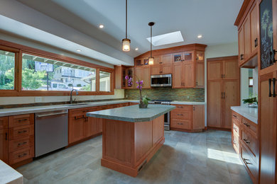 Foto på ett mellanstort, avskilt amerikanskt u-kök, med en undermonterad diskho, skåp i shakerstil, skåp i mellenmörkt trä, granitbänkskiva, flerfärgad stänkskydd, stänkskydd i stickkakel, klinkergolv i porslin och en köksö