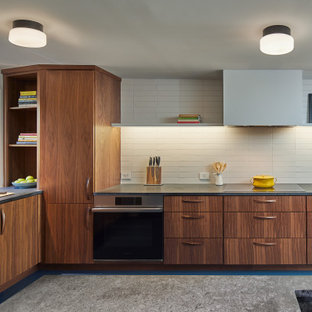 Design ideas for a midcentury kitchen in DC Metro with an integrated sink, flat-panel cabinets, medium wood cabinets, soapstone benchtops, white splashback, ceramic splashback, stainless steel appliances, linoleum floors, blue floor and grey benchtop.
