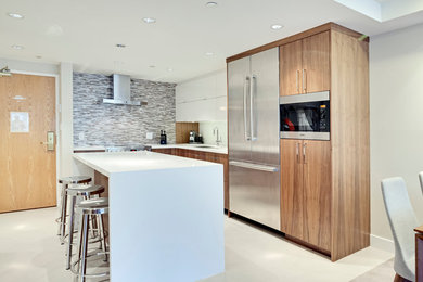 Design ideas for a medium sized contemporary l-shaped kitchen in Vancouver with a submerged sink, medium wood cabinets, grey splashback, ceramic splashback, stainless steel appliances, ceramic flooring and an island.