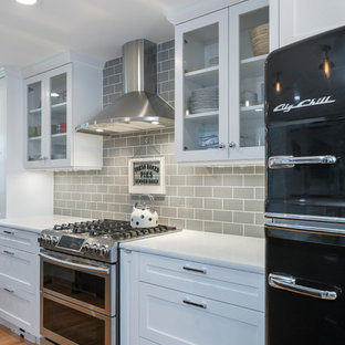 Small transitional open concept kitchen inspiration - Small transitional medium tone wood floor and brown floor open concept kitchen photo in Kansas City with an undermount sink, shaker cabinets, white cabinets, quartz countertops, gray backsplash, ceramic backsplash, black appliances and a peninsula