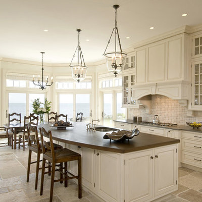 Elegant eat-in kitchen photo in Boston with raised-panel cabinets, white cabinets, limestone backsplash and brown countertops
