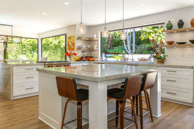 Eat-in kitchen - mid-sized transitional u-shaped light wood floor and brown floor eat-in kitchen idea in Orange County with an undermount sink, shaker cabinets, white cabinets, marble countertops, brown backsplash, a peninsula and gray countertops