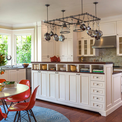 Eat-in kitchen - mid-sized transitional l-shaped medium tone wood floor eat-in kitchen idea in San Francisco with white cabinets, stainless steel countertops, green backsplash, stone tile backsplash and paneled appliances