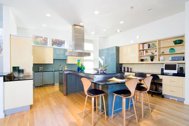 Large trendy u-shaped light wood floor eat-in kitchen photo in Dallas with flat-panel cabinets, light wood cabinets, an island, a double-bowl sink, granite countertops, green backsplash, glass tile backsplash and paneled appliances