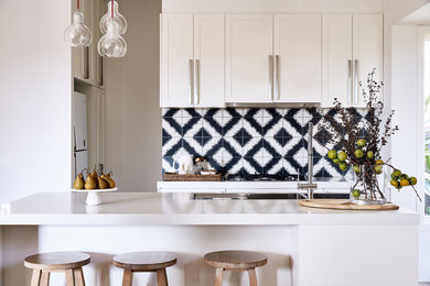 Foto på ett kök med öppen planlösning, med skåp i shakerstil, vita skåp, bänkskiva i kvarts och en köksö