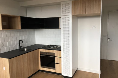 Foto di una cucina con ante in legno chiaro e top in acciaio inossidabile