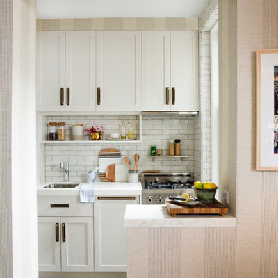 Eat-in kitchen - small contemporary l-shaped light wood floor and beige floor eat-in kitchen idea in New York with an undermount sink, shaker cabinets, white cabinets, marble countertops, white backsplash, subway tile backsplash, stainless steel appliances and a peninsula