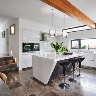 Design ideas for a large contemporary l-shaped kitchen/diner in Other with a submerged sink, flat-panel cabinets, white cabinets, glass sheet splashback, integrated appliances, an island, grey floors and white worktops.