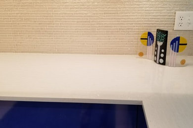Modelo de cocinas en L minimalista de tamaño medio con salpicadero metalizado y salpicadero de azulejos de vidrio
