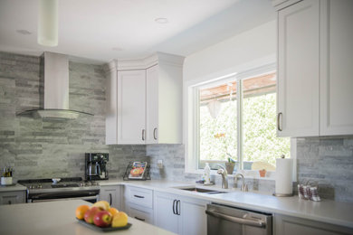 Mid-sized trendy l-shaped cement tile floor and gray floor kitchen pantry photo in Vancouver with a double-bowl sink, recessed-panel cabinets, white cabinets, quartz countertops, gray backsplash, stainless steel appliances, an island and white countertops