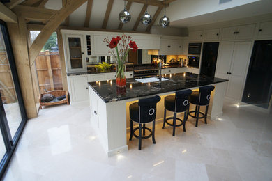 Diseño de cocina contemporánea grande abierta con encimera de mármol, suelo de piedra caliza, una isla y fregadero bajoencimera