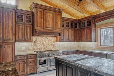 Inredning av ett klassiskt stort kök, med en rustik diskho, luckor med upphöjd panel, skåp i mellenmörkt trä, granitbänkskiva, beige stänkskydd, stänkskydd i stenkakel, rostfria vitvaror, klinkergolv i keramik och en köksö