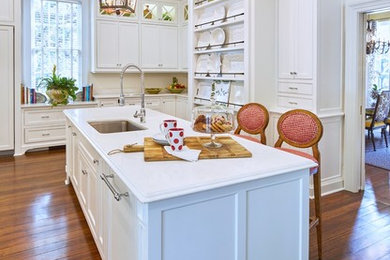Inspiration for a large transitional u-shaped medium tone wood floor open concept kitchen remodel in Charleston with an undermount sink, white cabinets, white backsplash, paneled appliances and an island