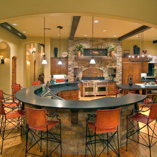 Imagen de cocina mediterránea con fregadero bajoencimera, armarios con paneles con relieve y puertas de armario de madera oscura